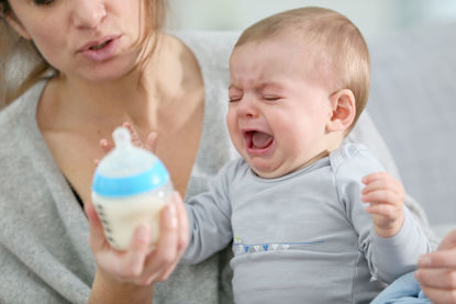 woman feeding a crying infant