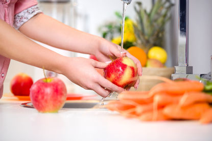 person washing fruits and vegetables