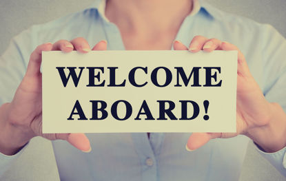 person holding a welcome aboard sign