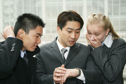 three people looking at the watch of the person in the middle