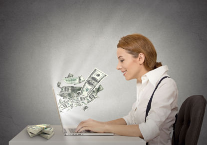 woman at a computer with money coming out of it
