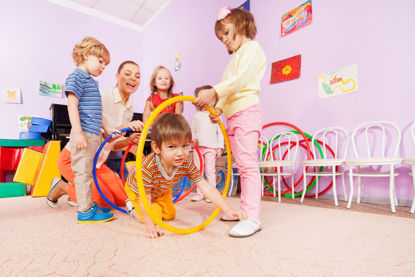 children crawling through hoops during indoor play 