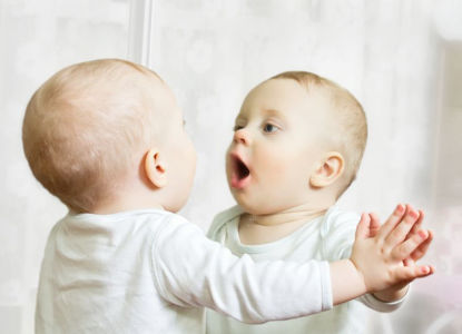 infant looking at reflection in mirror