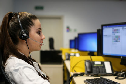 woman with headset looking at computer monitors